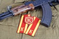 AK 47 with Soviet Army Cadet shoulder mark and Commandant shoulder patch on khaki uniform background