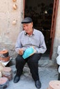 Unidentified Pottery artist coloring pot in front of store