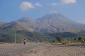 A white Audi and man on motor bike driving in dirty road with cloud of dust Royalty Free Stock Photo