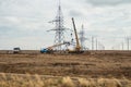 Special equipment and truck cranes work near high-voltage power transmission towers.