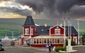 Traditional icelandic red wood building, weather change with dark storm clouds announcing upcoming thunderstorm Royalty Free Stock Photo