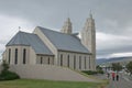 The back side of Akureyrarkirkja church in Akureyri in Iceland and people going for the service