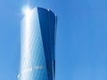 Al Bidda Tower on blue background with sun highlight and copyspace. Modern skyscraper with glazed facade