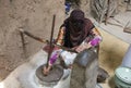 Omaniya grinding wheat in a traditional way