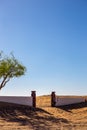 Al Madam ghost village, abandoned courtyard and brick fence with entry gate buried in sand in Sharjah, United Arab Emirates Royalty Free Stock Photo