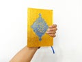 hand holding Al-Qur'an gold cover on withe background Royalty Free Stock Photo