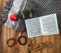 Al Qur& x27;an, bracelet, flower and shawl on wood background