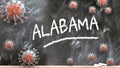 Alabama and covid virus - pandemic turmoil and Alabama pictured as corona viruses attacking a school blackboard with a written