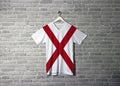 Alabama flag on shirt and hanging on the wall with brick pattern wallpaper. The states of America Royalty Free Stock Photo