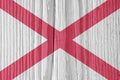 Alabama state flag on dry wooden surface. Light, pale, faded paints. Background, wallpaper or backdrop made of old wood with the Royalty Free Stock Photo