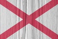 Alabama state flag on dry wooden surface. Light, pale, faded paints. Background, wallpaper or backdrop made of old wood with the Royalty Free Stock Photo