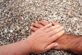 Alacati hands in the photo stones on the beach, female and male hands