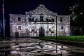 The Alamo in San Antonio, Texas during night after a rainfall with the building reflecting in water puddles