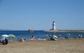Alanya, Turkey - August, 8, 2019: View to the Alanya Deniz Feneri Alanya lighthouse from the beach.  People relax on the Mediter Royalty Free Stock Photo