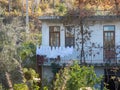 Alanya, Turkey - Jan 4, 2023. Old rustic residential building with laundry drying on the balcony surrounded by garden trees Royalty Free Stock Photo