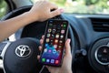 Woman hand holding iPhone with Widgets call IOS14 the car