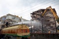 A yellow excavator is working on demolishing an old house Royalty Free Stock Photo