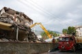 A yellow excavator is working on demolishing an old house in the city of Alanya, Turkey Royalty Free Stock Photo