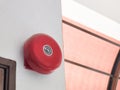 Alarm bell or emergency fire alarm mount on white concrete wall.