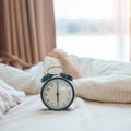 alarm clock with asian woman in bed while sleeping, young adult female wake up late in the early morning. Relaxing , sleepy, daily Royalty Free Stock Photo