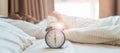 alarm clock with asian woman in bed while sleeping, young adult female wake up late in the early morning. Relaxing , sleepy, daily Royalty Free Stock Photo