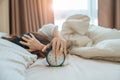 alarm clock and asian woman hand stop time in bed while sleeping, young adult female wake up late in the early morning. Relaxing Royalty Free Stock Photo