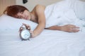 Alarm clock and asian woman hand stop time in bed while sleeping, young adult female wake up late in the morning. fresh relax,