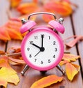 Alarm clock and autumn leaves, back to school or fall concept