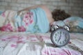 Alarm clock on the background of a sleeping person. The concept of sleep