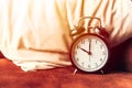 Alarm clock on the bed at the pillow for sleeping times wake up timer concept Royalty Free Stock Photo