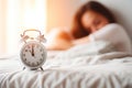 Alarm clock on bedside table in bedroom with woman sleeping on bed in blurred background. Generative AI Royalty Free Stock Photo