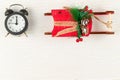 Alarm clock in a black case and red sleigh of santa claus on a white background with gold veins Royalty Free Stock Photo