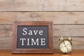 Alarm clock and blackboard with text `Save time`` Royalty Free Stock Photo