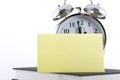 Alarm clock with blank adhesive note Royalty Free Stock Photo