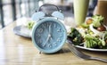 Alarm blue clock which schedule of meal for weight loss and Intermittent fasting concept