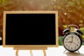 Alarm clock and chalkboard or blackboard in the public park for your text board plan with time concept