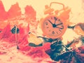 Alarm clock in colorful autumn leaves against a dark background with shallow depth of field. Daylight savings time concept. Alarm Royalty Free Stock Photo