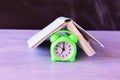 Alarm clock covered with open book, education concept Royalty Free Stock Photo
