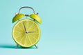 Alarm clock with a cut lime fruit instead of the clock face. Summer time, welcome summer. Creative minimal concept, vitamins, Royalty Free Stock Photo