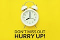 Alarm clock with Don`t miss out hurry up text on yellow background Royalty Free Stock Photo