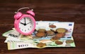 Alarm clock with euro money bills and coins, saving energy, home finances Royalty Free Stock Photo