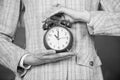 Alarm clock in female hands close up. Teachers attributes. Alarm clock in hands of teacher or educator classroom