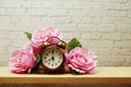 Alarm clock with flower decorative on white brick wall background Royalty Free Stock Photo