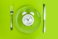 Alarm clock with fork and knife on the table. Time to eat, Breakfast, Lunch Time and Dinner concept Royalty Free Stock Photo
