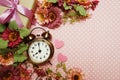 Alarm clock and gift box with roses bouquet with space copy on pink polka dot background Royalty Free Stock Photo