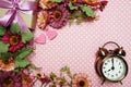 Alarm clock and gift box with roses bouquet on pink polka dot background Royalty Free Stock Photo