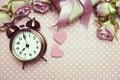 Alarm clock and gift box with roses bouquet with space copy on pink polka dot background Royalty Free Stock Photo