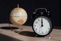 Alarm clock and globe on a wooden table. It`s time to travel. World time.