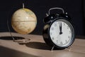 Alarm clock and globe on a wooden table. It`s time to travel. World time.