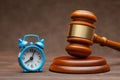 Alarm clock and hammer judge gavel on brown Royalty Free Stock Photo